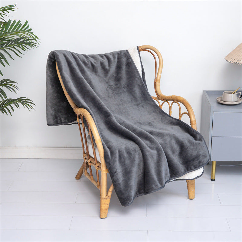 Gray washable pee pad blanket draped over a rattan chair