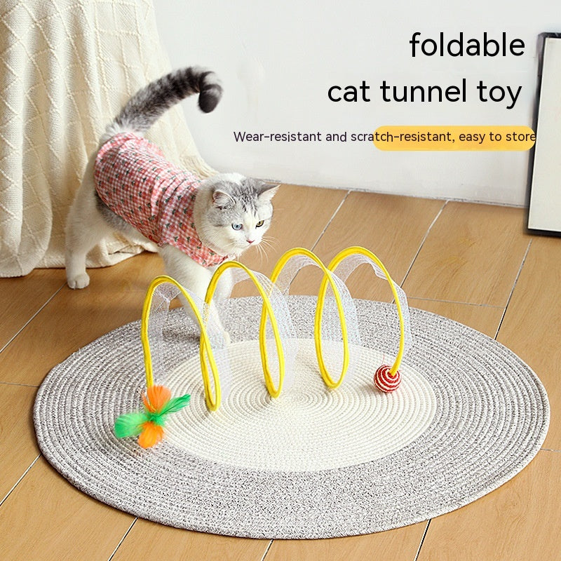 Kitten playing with the yellow spring cat tunnel