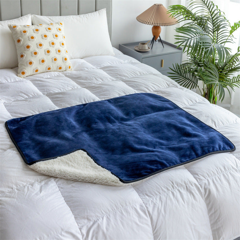 Navy washable pee pad blanket spread on a white bed