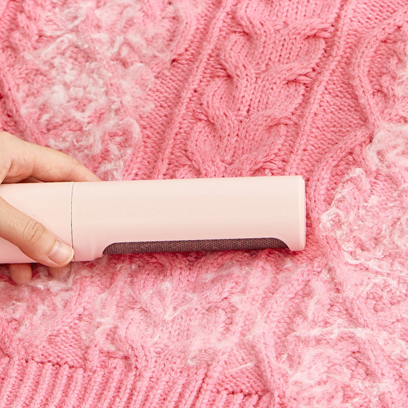 Pet hair remover roller being swiped across a pink knit blanket