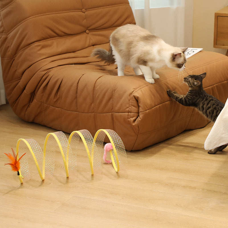 Cat jumping near the spring tunnel on a sofa