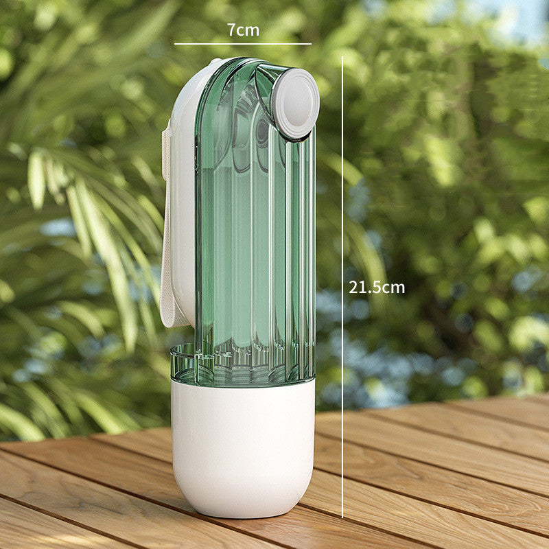 Green 2-in-1 travel water bottle on a wooden table outdoors