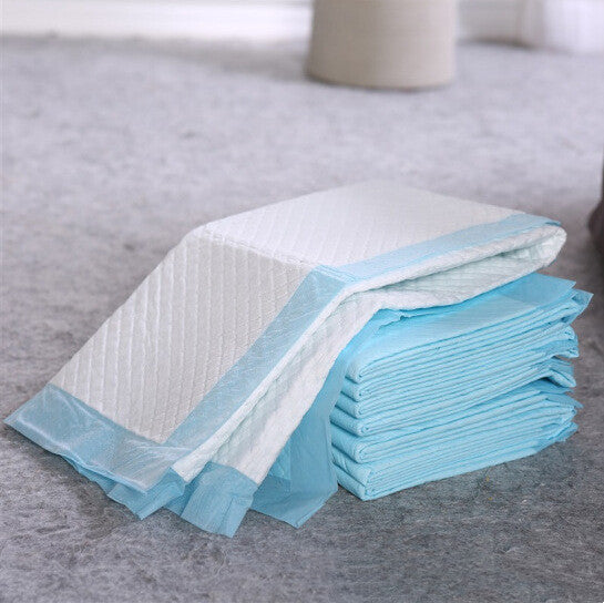 Disposable pee pads fanned out on a gray carpet