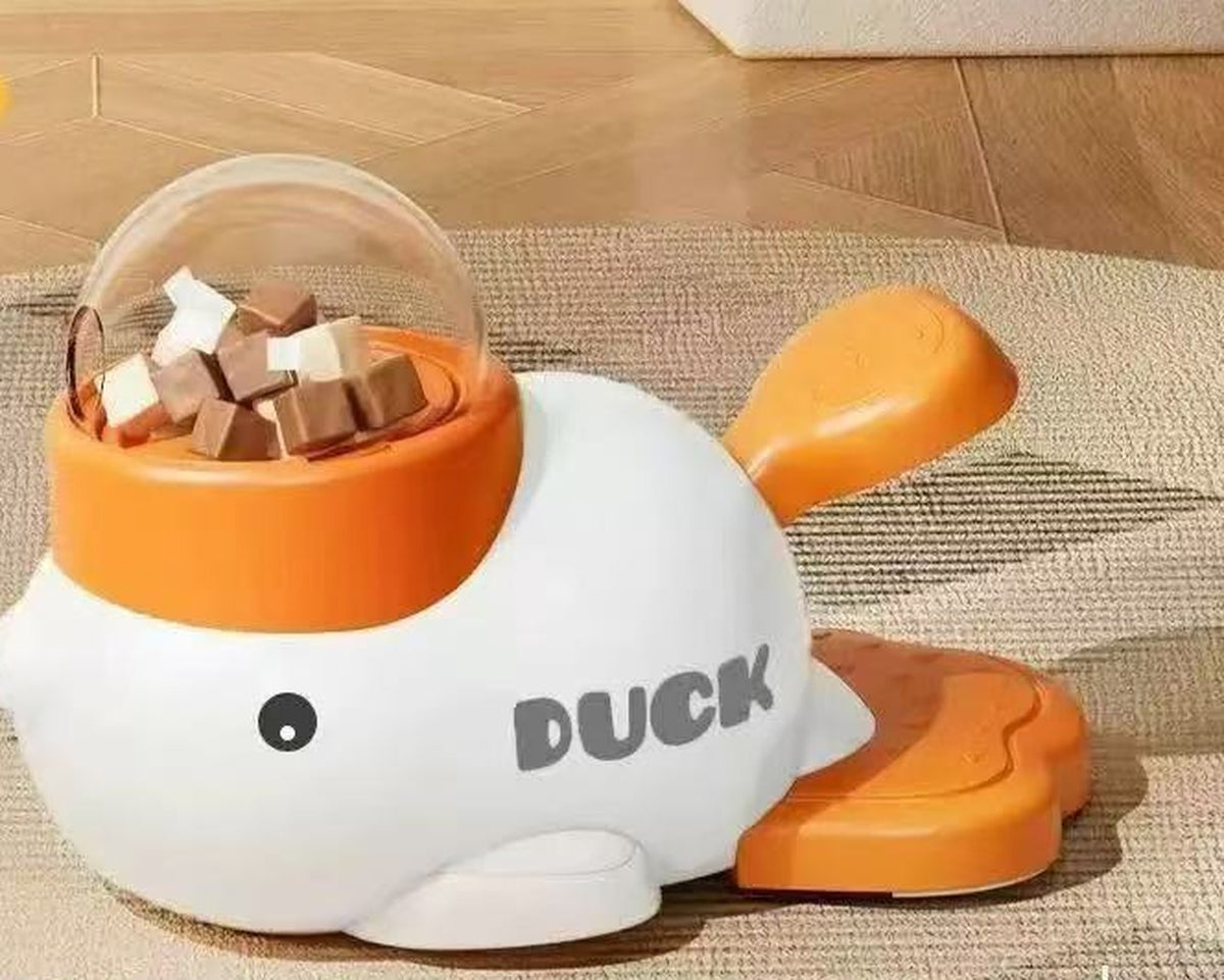 White duck slow feeder dog puzzle toy with orange treat dome and paddle